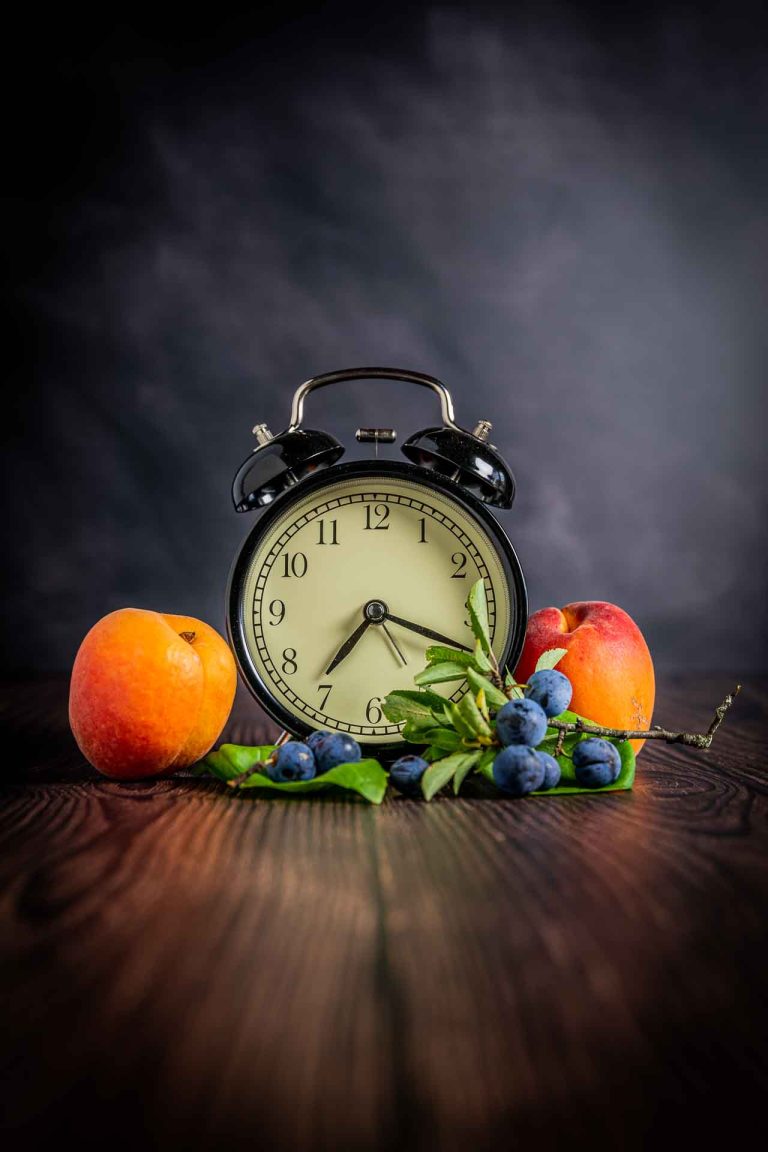 Photos fruits et légumes. Deux abricots autour d'un réveil.